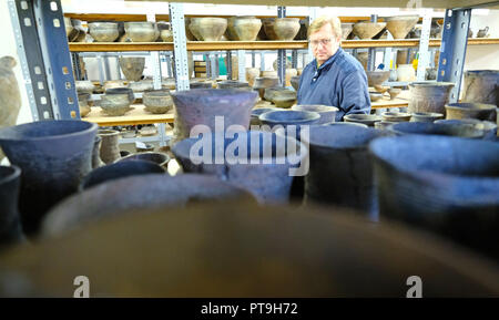02 Oktober 2018, Sachsen-Anhalt, Halle: 02. Oktober 2018, Deutschland, Halle: Archäologe Roman Mischker steht im Zentrallager des Staatlichen Amtes für Denkmalpflege und Archäologie Sachsen-anhalt auf Regalen mit Schiffen aus der Jungsteinzeit. Das Museum der Urgeschichte vom Staatlichen Amt feiert 100-jähriges Jubiläum. Foto: Sebastian Willnow/dpa-Zentralbild/dpa Stockfoto