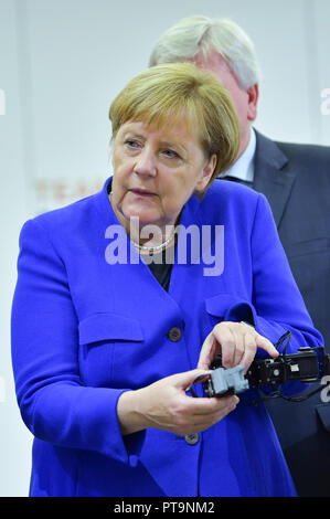 Darmstadt, Hessen, Deutschland. 08 Okt, 2018. Bundeskanzlerin Angela Merkel (CDU), mit Hilfe eines Studenten, der humanoide Roboter Johnny bei einem Besuch der Technischen Universität. Während einer Demonstration, der Suche und Rettung Roboter aus "Hector" Team eingesetzt, die können, zum Beispiel, können selbstständig für Menschen begraben. Foto: Uwe Anspach/dpa/Alamy leben Nachrichten Stockfoto