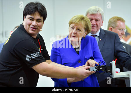 Darmstadt, Hessen, Deutschland. 08 Okt, 2018. Die deutsche Bundeskanzlerin Angela Merkel und der Hessische Ministerpräsident Volker Bouffier (r, beide CDU), mit Hilfe eines Studenten, der humanoide Roboter Johnny bei einem Besuch der Technischen Universität. Während einer Demonstration, der Suche und Rettung Roboter aus "Hector" Team eingesetzt, die können, zum Beispiel, können selbstständig für Menschen begraben. Foto: Uwe Anspach/dpa/Alamy leben Nachrichten Stockfoto