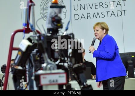 Darmstadt, Hessen, Deutschland. 08 Okt, 2018. Bundeskanzlerin Angela Merkel (CDU) steht neben humanoide Roboter Johnny bei einem Besuch der Technischen Universität. Während einer Demonstration, der Suche und Rettung Roboter aus "Hector" Team eingesetzt, die können, zum Beispiel, können selbstständig für Menschen begraben. Foto: Uwe Anspach/dpa/Alamy leben Nachrichten Stockfoto