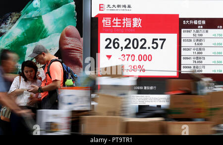 Hong Kong. 8. Oktober, 2018. Fußgänger vorbei an einem digitalen Bildschirm, der Benchmark Hang Seng Index in der South China Hong Kong, Oktober 8, 2018. Hong Kong stocks Geschlossen 370 Punkte oder 1,39 Prozent auf 26,202.57 Punkte am Montag. Credit: Li Gang/Xinhua/Alamy leben Nachrichten Stockfoto