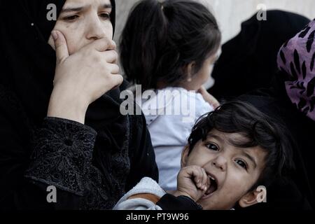 Athen, Griechenland. 8. Oktober, 2018. Eine Frau gesehen, die ihr Kind außerhalb des Ministeriums für Migrationspolitik, während der Protest der Flüchtlinge über die Bedingungen der Flüchtlingslager. Credit: Giorgos Zachos/SOPA Images/ZUMA Draht/Alamy leben Nachrichten Stockfoto