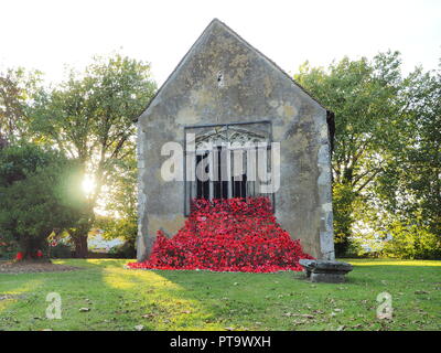 Murston, Kent, Großbritannien. 8. Oktober, 2018. UK Wetter: die Sonne hinter Murston alte Kirche, die mit Tausenden von Mohn von der Murston Herzen Poppy Projekt 2018 eingerichtet wurde, um die WW1 100 2018 zu gedenken. Murston Herzen Projekt und Vertiefungen in der Blüte arbeiten mit den Leuten von Swale und haben über 3000 einzigartige Mohnblumen, die jetzt einer von über 3000 gefallenen Helden aus der ganzen Swale Bereich, starben im Ersten Weltkrieg dar. Credit: James Bell/Alamy leben Nachrichten Stockfoto