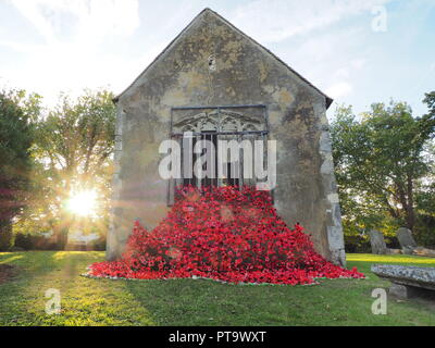 Murston, Kent, Großbritannien. 8. Oktober, 2018. UK Wetter: die Sonne hinter Murston alte Kirche, die mit Tausenden von Mohn von der Murston Herzen Poppy Projekt 2018 eingerichtet wurde, um die WW1 100 2018 zu gedenken. Murston Herzen Projekt und Vertiefungen in der Blüte arbeiten mit den Leuten von Swale und haben über 3000 einzigartige Mohnblumen, die jetzt einer von über 3000 gefallenen Helden aus der ganzen Swale Bereich, starben im Ersten Weltkrieg dar. Credit: James Bell/Alamy leben Nachrichten Stockfoto