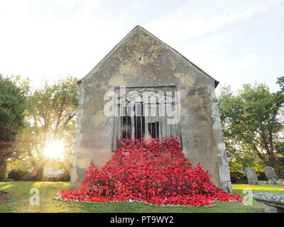 Murston, Kent, Großbritannien. 8. Oktober, 2018. UK Wetter: die Sonne hinter Murston alte Kirche, die mit Tausenden von Mohn von der Murston Herzen Poppy Projekt 2018 eingerichtet wurde, um die WW1 100 2018 zu gedenken. Murston Herzen Projekt und Vertiefungen in der Blüte arbeiten mit den Leuten von Swale und haben über 3000 einzigartige Mohnblumen, die jetzt einer von über 3000 gefallenen Helden aus der ganzen Swale Bereich, starben im Ersten Weltkrieg dar. Credit: James Bell/Alamy leben Nachrichten Stockfoto