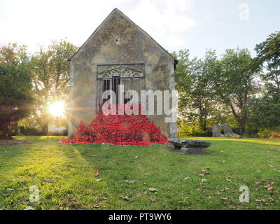 Murston, Kent, Großbritannien. 8. Oktober, 2018. UK Wetter: die Sonne hinter Murston alte Kirche, die mit Tausenden von Mohn von der Murston Herzen Poppy Projekt 2018 eingerichtet wurde, um die WW1 100 2018 zu gedenken. Murston Herzen Projekt und Vertiefungen in der Blüte arbeiten mit den Leuten von Swale und haben über 3000 einzigartige Mohnblumen, die jetzt einer von über 3000 gefallenen Helden aus der ganzen Swale Bereich, starben im Ersten Weltkrieg dar. Credit: James Bell/Alamy leben Nachrichten Stockfoto