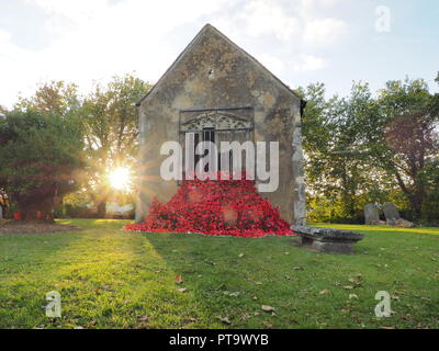 Murston, Kent, Großbritannien. 8. Oktober, 2018. UK Wetter: die Sonne hinter Murston alte Kirche, die mit Tausenden von Mohn von der Murston Herzen Poppy Projekt 2018 eingerichtet wurde, um die WW1 100 2018 zu gedenken. Murston Herzen Projekt und Vertiefungen in der Blüte arbeiten mit den Leuten von Swale und haben über 3000 einzigartige Mohnblumen, die jetzt einer von über 3000 gefallenen Helden aus der ganzen Swale Bereich, starben im Ersten Weltkrieg dar. Credit: James Bell/Alamy leben Nachrichten Stockfoto