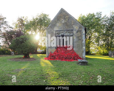 Murston, Kent, Großbritannien. 8. Oktober, 2018. UK Wetter: die Sonne hinter Murston alte Kirche, die mit Tausenden von Mohn von der Murston Herzen Poppy Projekt 2018 eingerichtet wurde, um die WW1 100 2018 zu gedenken. Murston Herzen Projekt und Vertiefungen in der Blüte arbeiten mit den Leuten von Swale und haben über 3000 einzigartige Mohnblumen, die jetzt einer von über 3000 gefallenen Helden aus der ganzen Swale Bereich, starben im Ersten Weltkrieg dar. Credit: James Bell/Alamy leben Nachrichten Stockfoto