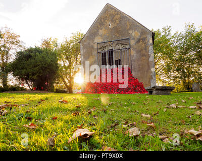 Murston, Kent, Großbritannien. 8. Oktober, 2018. UK Wetter: die Sonne hinter Murston alte Kirche, die mit Tausenden von Mohn von der Murston Herzen Poppy Projekt 2018 eingerichtet wurde, um die WW1 100 2018 zu gedenken. Murston Herzen Projekt und Vertiefungen in der Blüte arbeiten mit den Leuten von Swale und haben über 3000 einzigartige Mohnblumen, die jetzt einer von über 3000 gefallenen Helden aus der ganzen Swale Bereich, starben im Ersten Weltkrieg dar. Credit: James Bell/Alamy leben Nachrichten Stockfoto