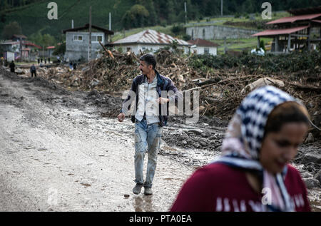 Mazandaran, Iran. 8. Oktober, 2018. Menschen gehen vorbei Rückstände nach Überschwemmungen durch starken Regen in einem Dorf in der Provinz Mazandaran, nördlichen Iran am 8. Oktober, 2018. Schwere Regenfälle in den nördlichen und nordwestlichen Teil des Iran am Freitag und Samstag ums Leben mindestens sieben Menschen. Credit: Ahmad Halabisaz/Xinhua/Alamy leben Nachrichten Stockfoto