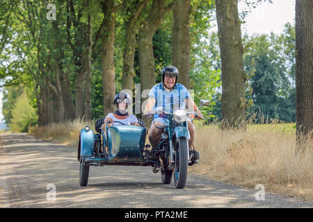 Freundliche Paar auf Classic Motor mit Beiwagen. Die Niederlande haben eine große Gruppe von Enthusiasten reiten Old Fashion Bikes. Stockfoto