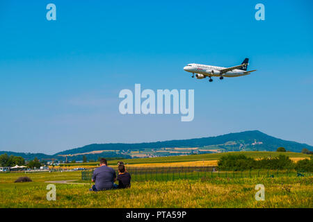 Vater und Sohn aufpassen Landung von Flugzeugen am Flughafen Zürich am sonnigen Tag Zeit Stockfoto