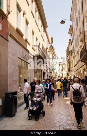 VERONA, ITALIEN - 6. Mai 2018: Touristen zu Fuß auf der Straße in den sonnigen Tag. Fußgängerzone in Verona vollgepackt mit Touristen und Käufer. Stockfoto