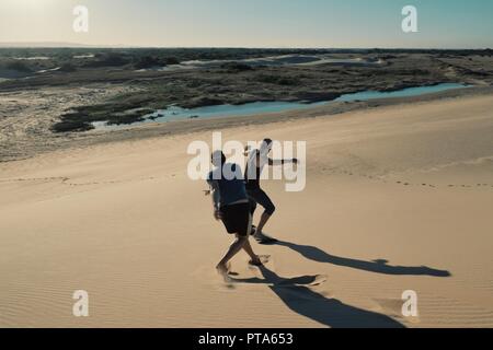 Santa Cruz, Bolivien - Sept. 5 2018: Zwei junge Mann Sandboarden in der Wüste Sand Dünen in der Nähe der Stadt Stockfoto