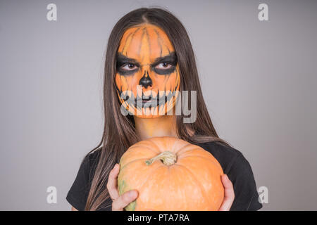 Portrait eines Mädchens mit einem erschreckend Make-up auf Halloween mit Kürbis urlaub Symbol Stockfoto