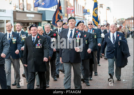 Gedenksonntagsparade, Veteranen, die Standards tragen, marschieren durch die Stadt Chichester, West Sussex, Großbritannien. Stockfoto