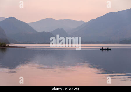 In Keswick, England, Großbritannien - 20 April 2009: Eine Gruppe Zeile ein Boot über Derwent Water, mit den Bergen der Kiefer der Borrowdale hinter, in Englands See Stockfoto