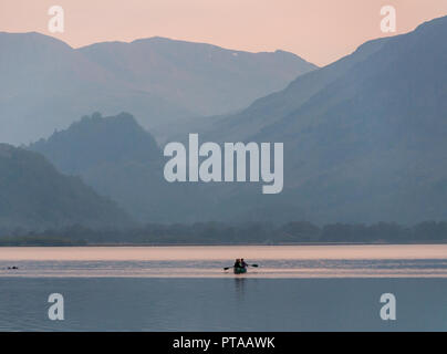 In Keswick, England, Großbritannien - 20 April 2009: Eine Gruppe Zeile ein Boot über Derwent Water, mit den Bergen der Kiefer der Borrowdale hinter, in Englands See Stockfoto