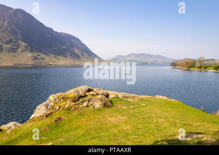 Buttermere, England, Großbritannien - 20 April 2009: ein Mann Zeilen einen kleinen Boot über Crummock Water See unter den Bergen des Lake District auf einem Sun Stockfoto