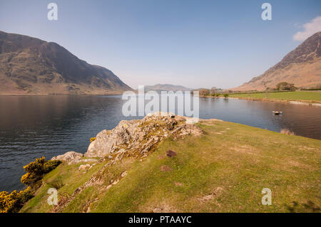 Buttermere, England, Großbritannien - 20 April 2009: ein Mann Zeilen einen kleinen Boot über Crummock Water See unter den Bergen des Lake District auf einem Sun Stockfoto