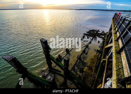 Der alte beschädigte Abschnitt des Southend Pier durch ein Feuer, das die Holzkonstruktion verbrennt und in das Wasser der Themse gefallen ist. Ebbe, die alte Holzarten enthüllt Stockfoto