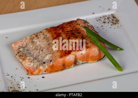 Gebratenes Lachssteak serviert grüne Zwiebel Stockfoto