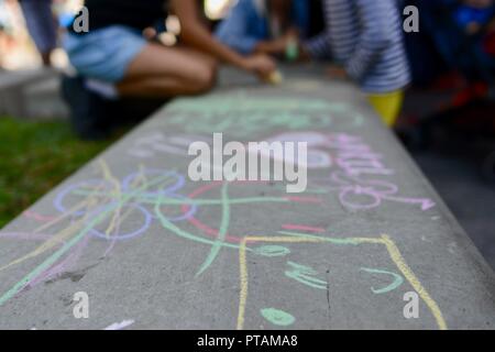 Kinder Zeichnen mit Kreide auf Beton, die Splinte Markt an der Flinders Street, Central Business District der Stadt Townsville, QLD, Australien Stockfoto