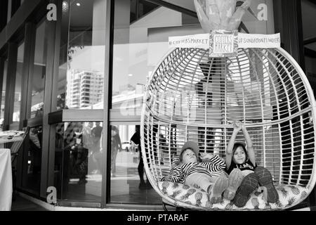 Kinder sitzen und entspannen in einem großen Ananas Stuhl, Splinte Markt an der Flinders Street, Central Business District der Stadt Townsville, QLD, Australien Stockfoto