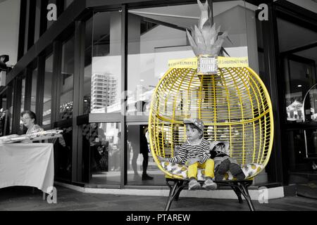 Kinder sitzen und entspannen in einem großen Ananas Stuhl, Splinte Markt an der Flinders Street, Central Business District der Stadt Townsville, QLD, Australien Stockfoto