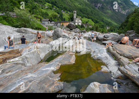 Lavertezzo, Schweiz - 9. Juni 2018: Menschen beim Sonnenbaden auf den Fluss in Lavertezzo in den Schweizer Alpen Stockfoto