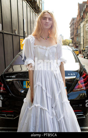 LONDON, Großbritannien - 14 September 2018: Leute auf der Straße, während der London Fashion Week. Ein Mann mit langen blonden Haar in einem weißen Kleid der Br gekleidet Stockfoto