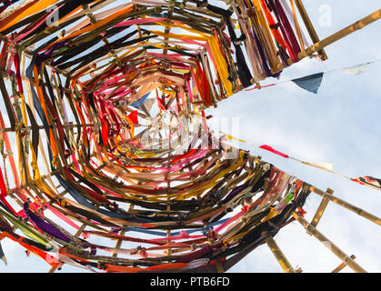 Nahaufnahme von einem Kreis-förmige multicolor Tuch pin Wheel mit unscharfen grünem Gras Hintergrund Stockfoto