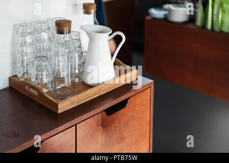 Transparente Gläser und weißes Metall Glas auf holzschrank im Cafe. Stockfoto