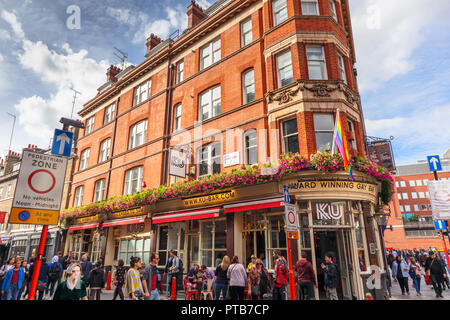 Ku Bar, einem beliebten und berühmten Gay Bar in Lisle Street, an einer geschäftigen voll Nachmittag in Chinatown in Soho, Westminster, das West End von London, Großbritannien Stockfoto