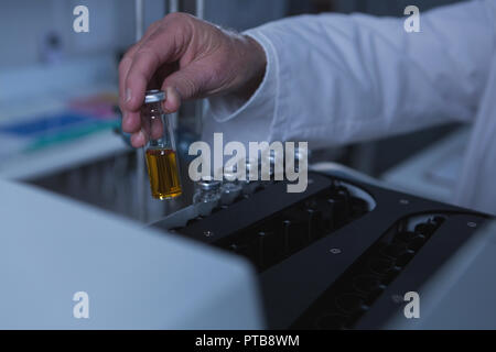 Männliche Wissenschaftler die chemischen Flasche auf eine Maschine 4 k Stockfoto