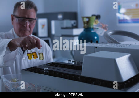 Männliche Wissenschaftler die chemischen Flasche auf eine Maschine 4 k Stockfoto