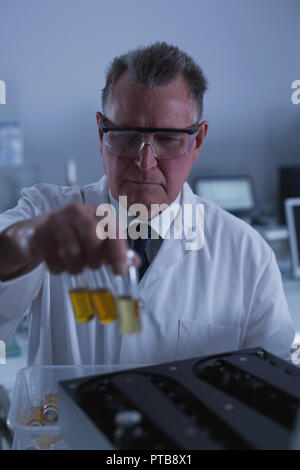 Männliche Wissenschaftler die chemischen Flasche auf eine Maschine 4 k Stockfoto