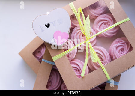 Köstliche rosa Hochzeit Marshmallows mit Herzen. Geschenkbox auf weißen, weichen, grünen, pastellfarbenen Hintergrund. Valentinstag, Geburtstag, Hochzeit Geschenk. Acht Meringue in Feld. Candy Bar Stockfoto