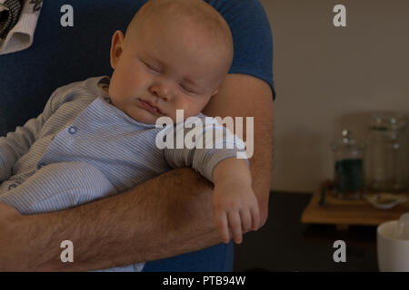 Baby schlafend in seinem Vater arm Stockfoto