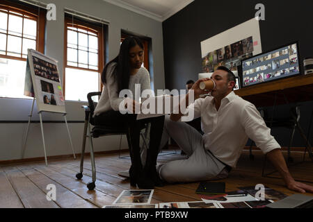 Kollegen diskutieren über einen Fotos während Kaffee Stockfoto