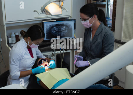 Weiblichen Zahnarzt und eine Krankenschwester untersuchen Patienten mit Tools Stockfoto