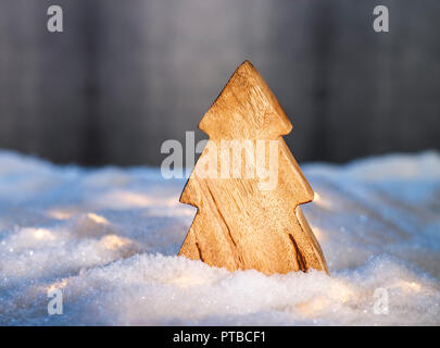 Holz Weihnachtsbaum in einer verschneiten Landschaft vor einem dunklen Hintergrund Stockfoto