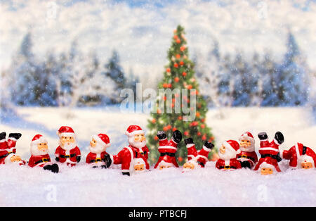 Eine große Anzahl von Santa Claus Zahlen vor der Winterlandschaft mit Weihnachtsbaum Stockfoto
