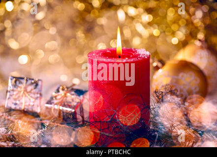 Rote Kerze mit Weihnachtsschmuck und Geschenkpaket Stockfoto