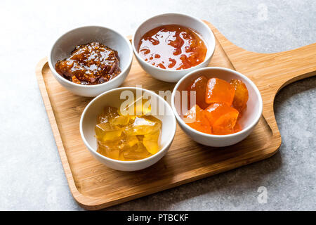 Verschiedene keramische Schüssel von Konfitüren Abb., Quitte, Bergamotte Citrus, Wassermelone in Holz- Fach-/Marmelade. Ökologische Lebensmittel. Stockfoto