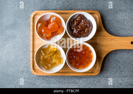 Verschiedene keramische Schüssel von Konfitüren Abb., Quitte, Bergamotte Citrus, Wassermelone in Holz- Fach-/Marmelade. Ökologische Lebensmittel. Stockfoto