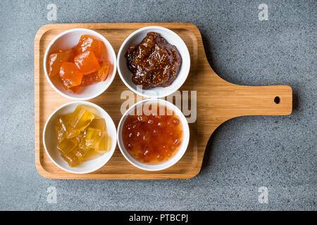 Verschiedene keramische Schüssel von Konfitüren Abb., Quitte, Bergamotte Citrus, Wassermelone in Holz- Fach-/Marmelade. Ökologische Lebensmittel. Stockfoto