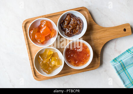 Verschiedene keramische Schüssel von Konfitüren Abb., Quitte, Bergamotte Citrus, Wassermelone in Holz- Fach-/Marmelade. Ökologische Lebensmittel. Stockfoto