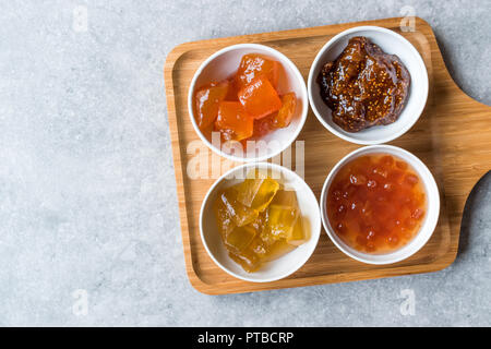 Verschiedene keramische Schüssel von Konfitüren Abb., Quitte, Bergamotte Citrus, Wassermelone in Holz- Fach-/Marmelade. Ökologische Lebensmittel. Stockfoto