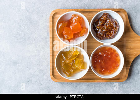 Verschiedene keramische Schüssel von Konfitüren Abb., Quitte, Bergamotte Citrus, Wassermelone in Holz- Fach-/Marmelade. Ökologische Lebensmittel. Stockfoto